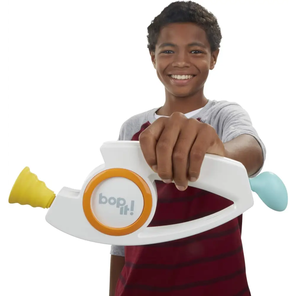 Boy playing with Hasbro Gaming Bop It! electronic game unit, enjoying classic dexterity games