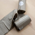 Rolls of gray biodegradable Nina Woof dog poop bags for eco-friendly puppy walks